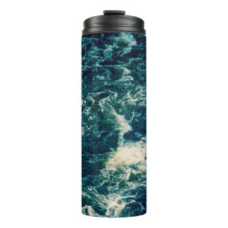 Hintergrund, obere Ansicht, rascher Fluss des Flus Thermosbecher