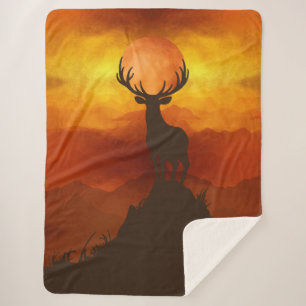 Hirsch auf dem Berggipfel beim Sonnenuntergang Sherpadecke