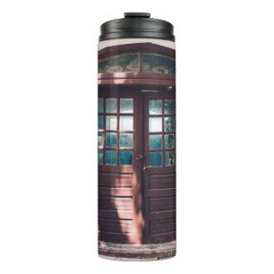 HOLZFENSTER AUF BLAUE KONKRETE WAND THERMOSBECHER