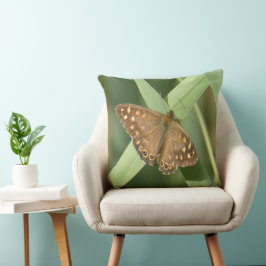Holzschmetterling auf dem grünen Kissen