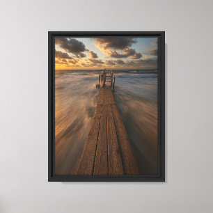 Holzsteg, der bei Sonnenuntergang in die Ozeanwell Leinwanddruck