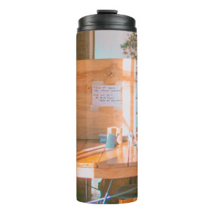 HOLZTISCH MIT WEISSEM DRUCKPAPIER THERMOSBECHER