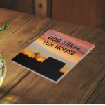 House Sessing Sunset Silhouette Fliese<br><div class="desc">Keramik Kachel mit dem Foto eines bunten Sonnenuntergangs zusammen mit einem Haussegen,  der "Gott segne dieses Haus" in schwarzer Schrift sagt. Wählen Sie Ihre Kachelgröße aus. Macht ein nachdenkliches Geschenk für Familie und Freunde.</div>