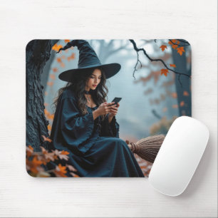 Hübsche Halloween-Hexe, die auf einem Mobiltelefon Mousepad