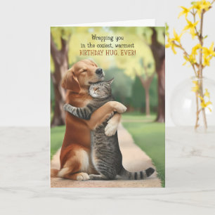 Hübscher Hund und Katze umarmen sich im Park zum G Karte