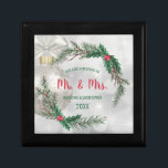 | Hübscher Kranz & Mrs. Erinnerungskiste<br><div class="desc">Feiern Sie Ihr erstes Lebensjahr zusammen mit dieser wertvollen Geschenkboxen "Unser erstes Weihnachtsfest". Dieses Design zeichnet sich durch einen hübschen silbernen Hintergrund mit einem weißen Weihnachtsschmuck und einem weißen Band aus. Darüber befindet sich ein eleganter Kranz mit Kiefernästen und Mistelbeeren. Der anpassbare Text lautet "Unser erstes Weihnachten als Herr. &...</div>