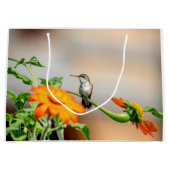 Hummingbird auf einer blühenden Pflanze Große Geschenktüte (Vorderseite)