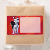 Husky in Weihnachtsmannmütze auf Rot (Insitu)