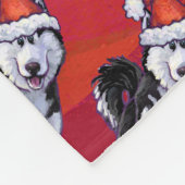 Husky in Weihnachtsmannmütze auf Rot Fleecedecke (Ecke)