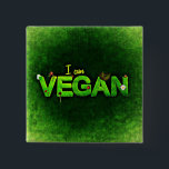 Ich bin Vegan mit einer grasbewachsenen Naturstruk Button<br><div class="desc">Ich bin vegan in hellgrün auf einer dunkelgrünen Leinwand wie Hintergrund geschrieben. Das Wort vegan ist mit einer grünen grasähnlichen Textur geschrieben. Kleine naturbezogene Ladybugs, Gänseblümchen und Blätter schmücken die Worte.</div>