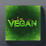 Ich bin Vegan mit einer grasbewachsenen Naturstruk Fotoplatte<br><div class="desc">Ich bin vegan in hellgrün auf einer dunkelgrünen Leinwand wie Hintergrund geschrieben. Das Wort vegan ist mit einer grünen grasähnlichen Textur geschrieben. Kleine naturbezogene Ladybugs,  Gänseblümchen und Blätter schmücken die Worte.</div>