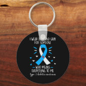 Ich trage einen blauen und grauen Typ 1 Diabetes Schlüsselanhänger (Vorderseite)