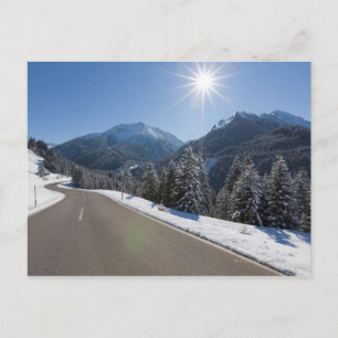 Idyllische leere Straße durch eine Winterlandschaf Postkarte