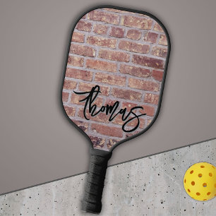 Ihr Name als Graffiti an einer Mauer aus rotem Zie Pickleball Schläger