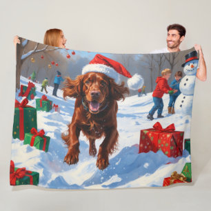 Irish Red Setter läuft durch Schnee mit Weihnachts Fleecedecke