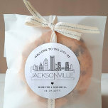 Jacksonville Skyline | Begrüßungsnachricht Runder Aufkleber<br><div class="desc">Erweitern Sie Ihre Hochzeitspakete oder Event-Gastgeschenke mit einem individuellen Set von Begrüßungsaufklebern! Diese eleganten, aber minimalistischen Aufkleber sind auf eine Hochzeit in der schönen Stadt Jacksonville zugeschnitten. Sie verfügen über eine moderne Skyline aus Deko, die den Namen der Stadt trägt und darunter integriert ist. Alle Elemente des Designs, einschließlich der...</div>