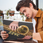 Jazzman Playing Gold Saxophon Foto Planer<br><div class="desc">Für Jazzmusikfans! Dieser monatlich/wöchentlich erscheinende Kalenderplaner behalte alle Ihre anstehenden Aktivitäten und Termine an einem praktischen Ort und zeigt das Foto eines Jazzmanns,  der sein altes,  goldfarbenes,  Tenor-Saxophonhorn spielt,  zusammen mit dem in goldfarbenen Blockbriefen gedruckten Wort "JAZZ". Wählen Sie Ihren Planerstil,  Größe und Drahtfarbe aus.</div>
