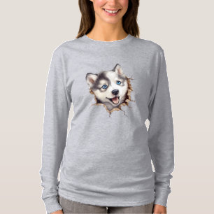 Jenseits der Barriere: Ein Husky-Welpe spielt T-Shirt