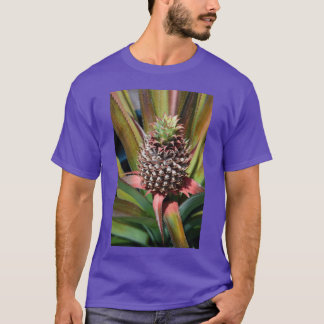 Junge Ananas, die unter der tropischen Sonne wächs T-Shirt