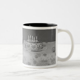 Junge bläst Kerzen aus Zweifarbige Tasse