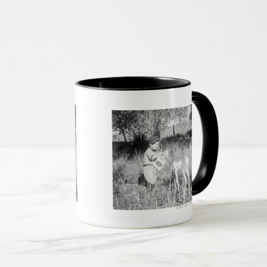 Junge, der Antilope füttert Tasse (VorderseiteRechts)