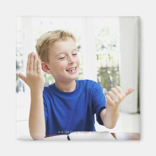 Junge, der auf seinen Fingern zählt, um seins Magnet