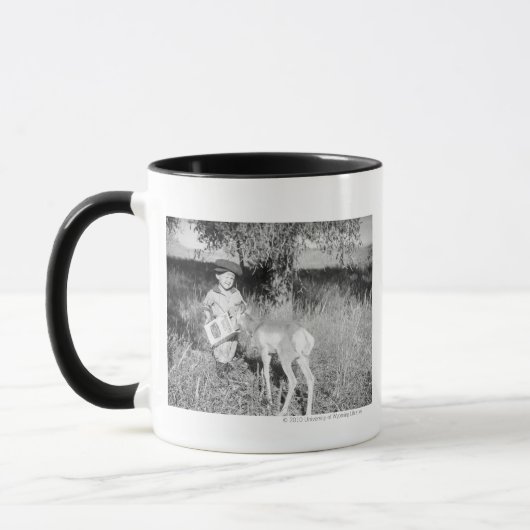 Junge, der eigenhändig Antilope füttert Tasse (Links)