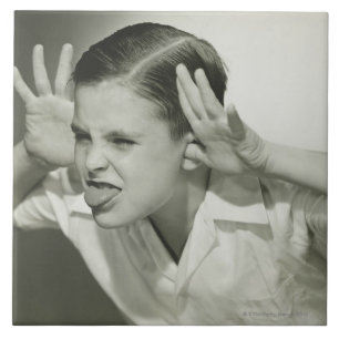 Junge, der Gesicht macht Fliese