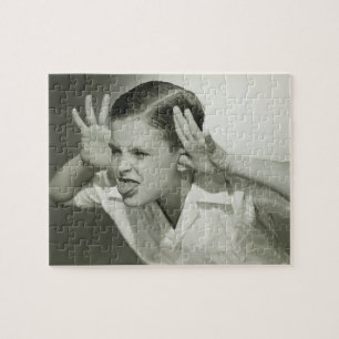 Junge, der Gesicht macht Puzzle