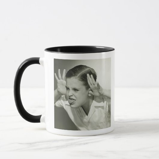 Junge, der Gesicht macht Tasse (Links)