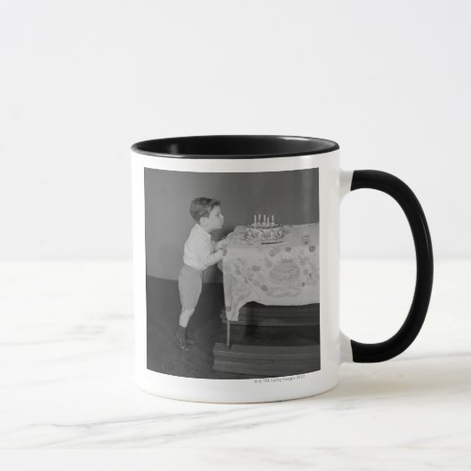 Junge, der heraus Kerzen durchbrennt Tasse (Rechts)