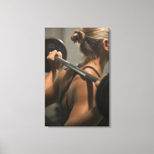 Junge Frau, die mit Barbell, hintere Ansicht Leinwanddruck