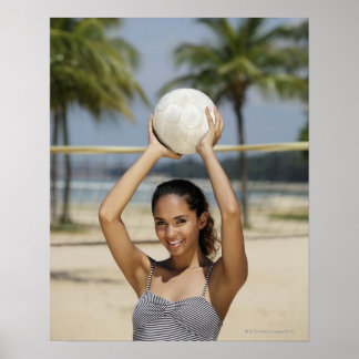 Junge Frau, die Volleyball hält und lächelt bei Poster