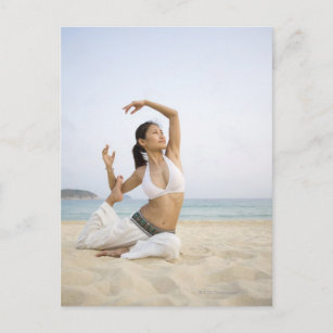 Junge Frau, die Yoga am Strand macht Postkarte