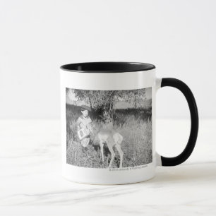 Junge füttert Antilope von Hand Tasse