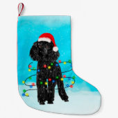 Junge Hündin sitzt im Schnee mit Weihnachtsmannmüt Kleiner Weihnachtsstrumpf (Vorderseite)