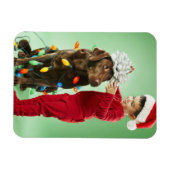 Junge Junge packt Weihnachtsleuchten um einen Hund Magnet (Horizontal)