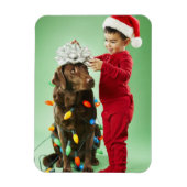 Junge Junge packt Weihnachtsleuchten um einen Hund Magnet (Vertikal)