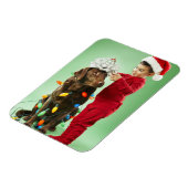 Junge Junge packt Weihnachtsleuchten um einen Hund Magnet (Linke Seite)