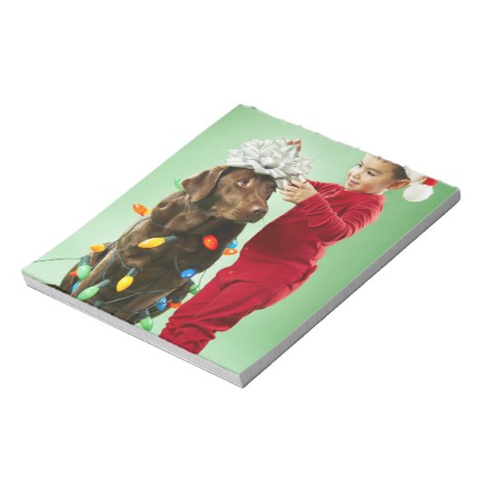 Junge Junge packt Weihnachtsleuchten um einen Hund Notizblock (Rotiert)