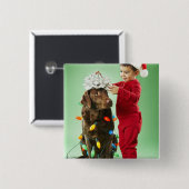 Junger Junge, der Weihnachtslichter um einen Hund Button (Vorne & Hinten)