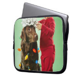 Junger Junge, der Weihnachtslichter um einen Hund Laptopschutzhülle (Vorderseite Links)