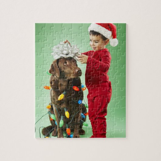 Junger Junge, der Weihnachtslichter um einen Hund Puzzle (Vertikal)