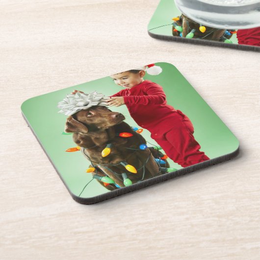 Junger Junge, der Weihnachtslichter um einen Hund Untersetzer (Linke Seite)