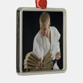 Junger Mann, der an Bretter mit Karatehieb bricht Silbernes Ornament (Rechts)