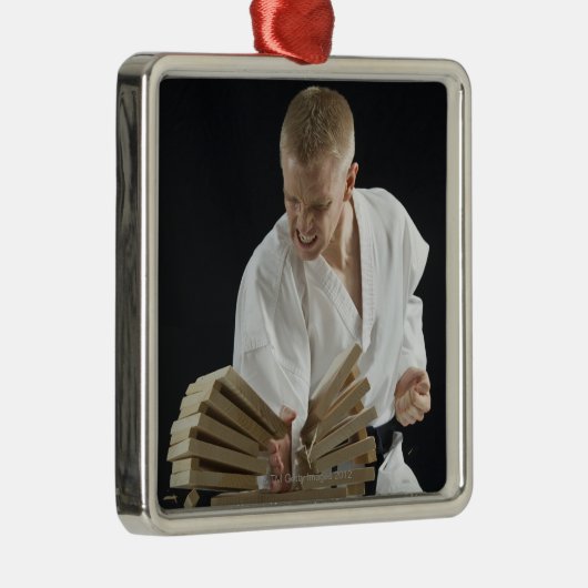 Junger Mann, der an Bretter mit Karatehieb bricht Silbernes Ornament (Rechts)