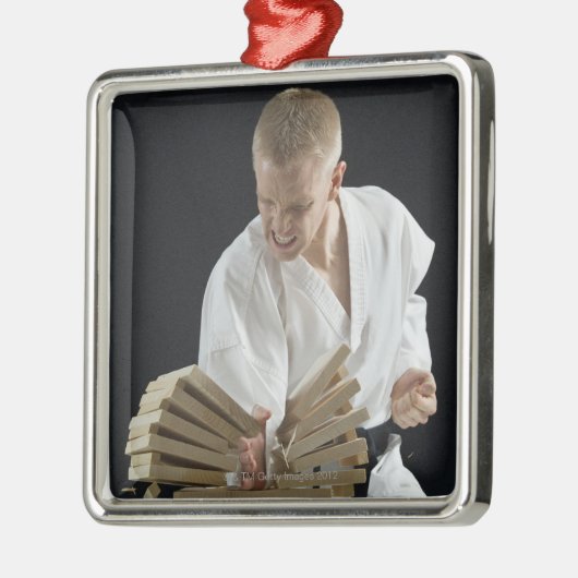Junger Mann, der an Bretter mit Karatehieb bricht Silbernes Ornament (Links)