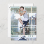 junger Mann, der in ausgewogener Weise eine Aufbau Postkarte (Vorne/Hinten)