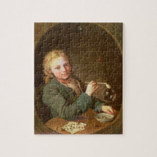 Junger Mann-durchbrennenblasen von einem Puzzle