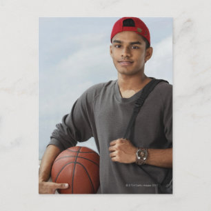 junger Mann mit rotem Oberteil mit Basketball und Postkarte